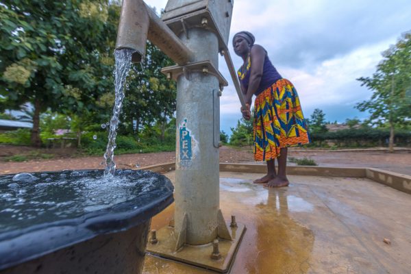 At Bopese, Evelyn Doe fetches water from the hand pump water borehole system donated to the community through the Rotary International-USAID Partnership projects. Bopese, Ghana. 25 June 2019. Rotarians from 35 clubs across the country are partnering with USAID and national and local agencies of the government of Ghana in a large-scale $4 million program in water, sanitation and hygiene serving 75,000 people. By working together, both partners leverage each other strengths for more sustainable impact in improving access to clean water and sanitation services, fostering the adoption of hygiene behavior, strengthen community management systems, and influencing decision makers for prioritized financing of local water and sanitation services.